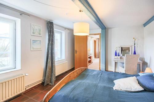 een slaapkamer met een blauw bed en 2 ramen bij Ferienwohnung Seehund in Emmelsbüll-Horsbüll