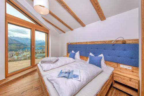 um quarto com uma cama grande com dois livros em Eagles Nest - by Alpen Apartments em Zell am See