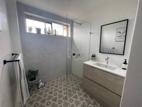 a bathroom with a shower and a sink and a mirror at Mindy's by the beach in East Ballina