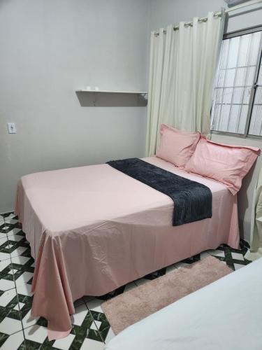 two beds in a bedroom with pink and blue sheets at Casa favorita in São Raimundo Nonato