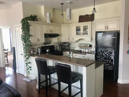 a kitchen with white cabinets and a black refrigerator at Market Place Living in Stratford