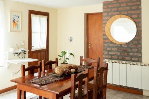 a dining room with a wooden table and chairs at Bandurrias in Esquel