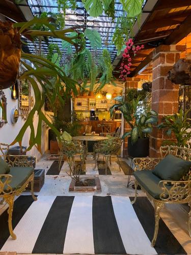 a patio with chairs and a table and plants at Selva María Hotel Boutique in Santa Fe de Antioquia