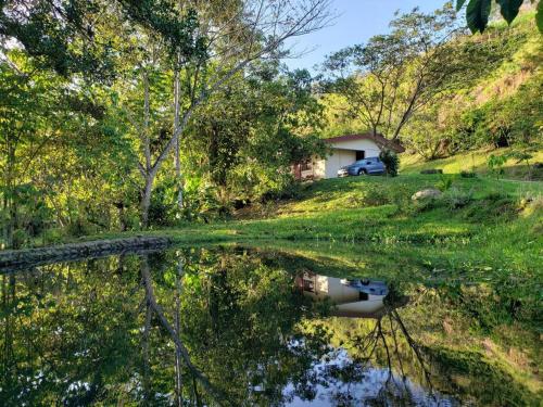 een weerspiegeling van een huis in een lichaam van water bij Studio House in Eco-Farm: nature, relaxing, hiking in Turrialba