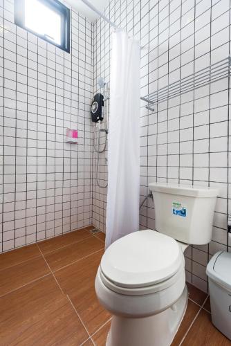a white bathroom with a toilet and a shower at Book a Bed Poshtel - SHA Plus in Phuket Town