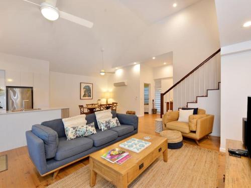 a living room with a blue couch and a coffee table at Beach Villa - a Short Walk to Town & Beach in Port Douglas