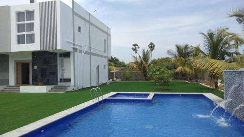 a house with a swimming pool in front of a house at Coastal Heaven Koovathur in Kūvattūr