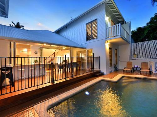 a house with a swimming pool in front of a house at Beach Villa - a Short Walk to Town & Beach in Port Douglas