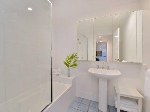 a white bathroom with a sink and a shower at Beach Villa - a Short Walk to Town & Beach in Port Douglas