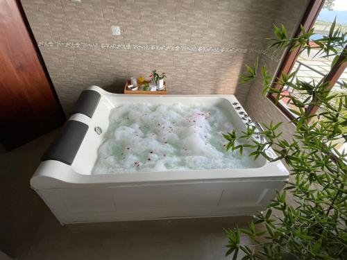 a bath tub with white foam in a bathroom at Hapu Tales - Private Holiday Villa in Haputale