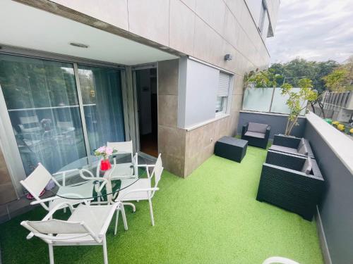 a patio with a table and chairs on a balcony at Luxe Forum Beach Terrace in Sant Adria de Besos