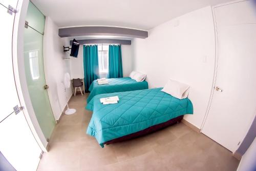 a small room with two beds and a mirror at LAS GAVIOTAS DE PARACAS in Paracas
