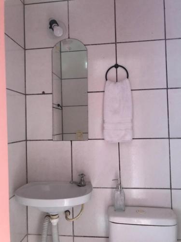 La salle de bains est pourvue d'un lavabo, d'un miroir et de toilettes. dans l'établissement Suíte na serra, à Guaramiranga