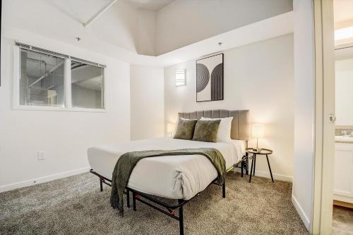 1 dormitorio con cama y ventana en CozySuites - 2BR with Direct Skybridge Access #11 en Indianápolis