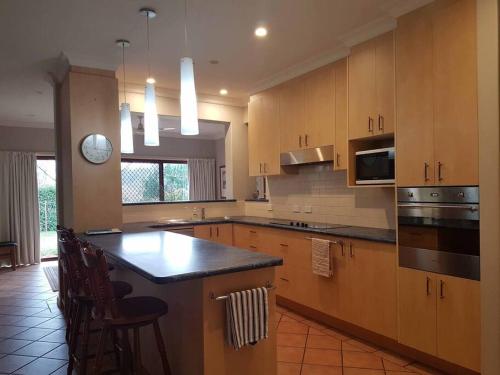 a kitchen with wooden cabinets and a black counter top at Topsys Corner - large rural house near Orange in Shadforth