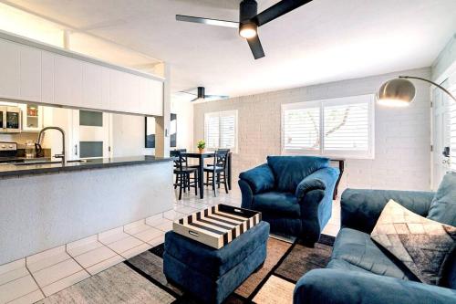 a living room with two blue chairs and a kitchen at Charming dog-friendly, 2BR-1BA with Pool, Mountain Views - Low Summer Rates! in Tucson