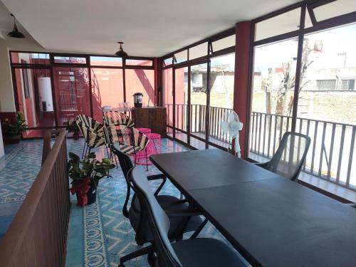 a room with a table and chairs on a balcony at Lidia Anturios in Oaxaca City