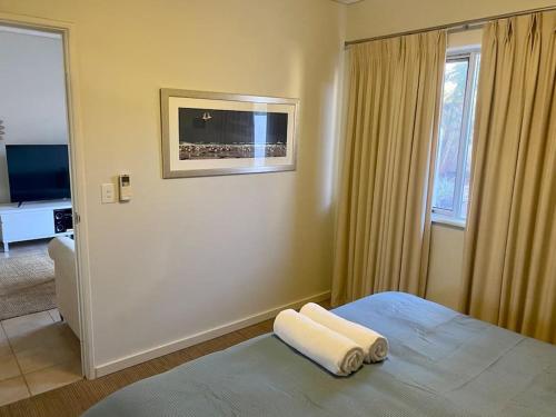 a bedroom with a bed with a towel on it at Mariner Resort Comfort - unit 165 in Geraldton