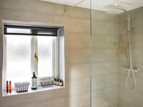 a bathroom with a shower with a glass door at Heather Cottage in Bishop Auckland