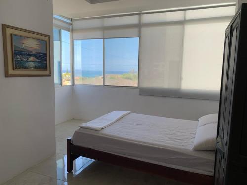 a bedroom with a bed with a view of the ocean at Brisa Blanca in Punta Blanca