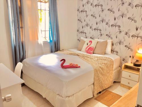 una camera da letto con un letto con due fenicotteri rosa sopra di Cozzy Flamingo a Concepción de La Vega