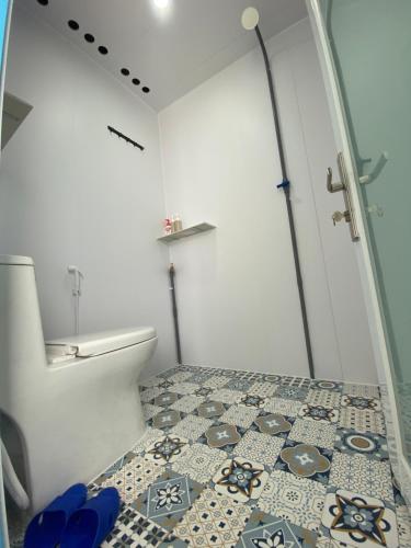 a bathroom with a toilet and a tile floor at nhà Ba cơm Má in Phương Phi