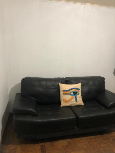 a black leather couch with a pillow on it at Tiago Barreto in Poços de Caldas