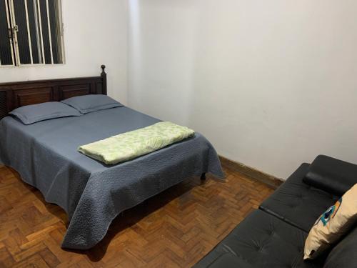 a bedroom with a bed and a couch at Tiago Barreto in Poços de Caldas