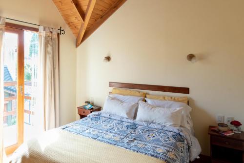 a bedroom with a bed with a blue and white comforter at Bandurrias in Esquel