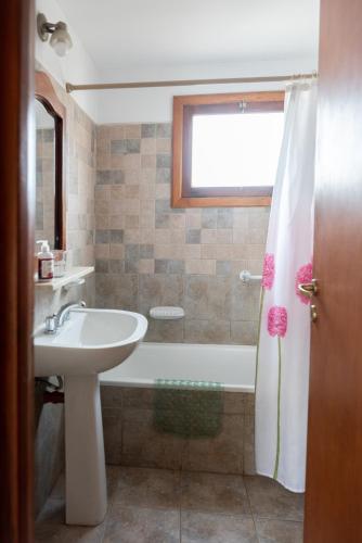 a bathroom with a sink and a bath tub at Casa Bandurrias in Esquel