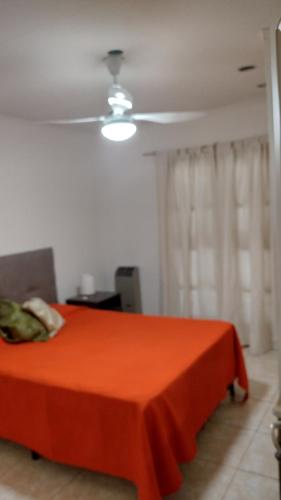 - une chambre avec un lit rouge et un ventilateur de plafond dans l'établissement Como en casa, à Mendoza