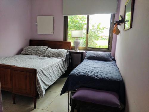 1 dormitorio con 2 camas y ventana en La Asunción 114 en Luján