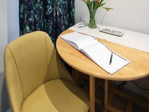 a table with a book and a pen on it at The Frome Studio in Frome