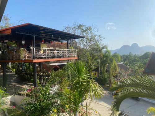 ein Gebäude mit einem Balkon mit Bäumen und Bergen im Hintergrund in der Unterkunft Krabi Villa Phu Khao Private Resort in Klong Muang Beach