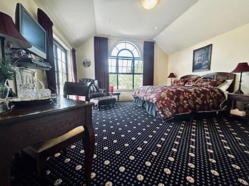 a hotel room with a bed and a desk and a desk at Fontainebleau Luxury B&B in Hanmer Springs