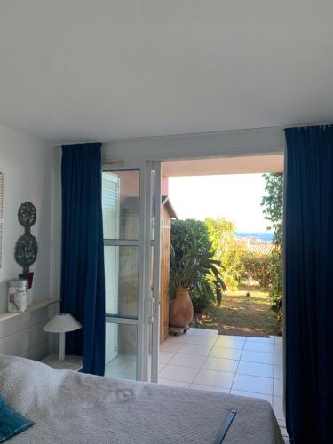 une chambre avec un lit et une porte coulissante en verre dans l'établissement Cap Estérel T3 jardin clôturé Grande terrasse couverte Vue Mer 2 chambres Village vacances Pierre et vacances, à Saint-Raphaël