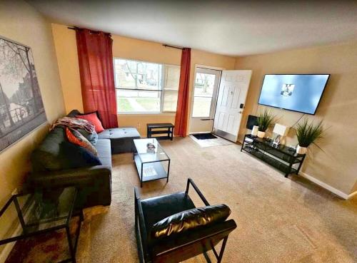 a living room with a couch and a flat screen tv at Perfect for family visits to Washington DC or UMD! in College Park