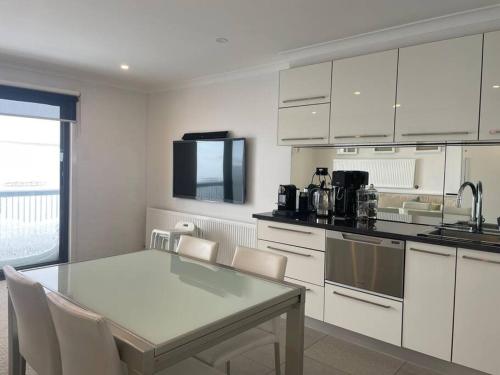 a kitchen with white cabinets and a table and chairs at Lawlers 42 in Mount Hotham