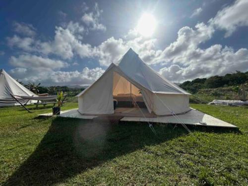拉耶的住宿－North Shore Glamping / Camping Laie, Oahu, Hawaii，天空中阳光明媚的田野上的两个帐篷