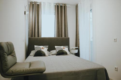 a bedroom with a bed and a chair at Balkon-Apartment in Krefeld: Komfort & Stil nahe Düsseldorf in Krefeld