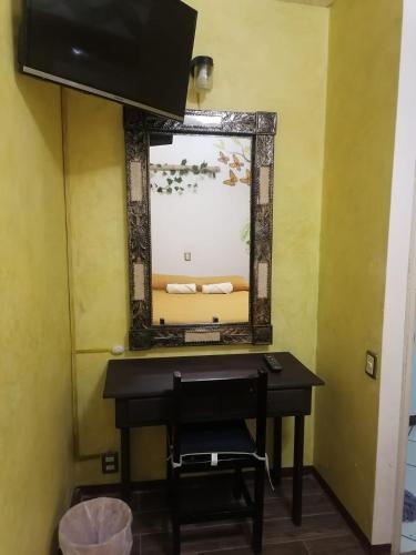 a mirror on a wall next to a desk with a mirror at Casa los Arcos Oaxaca in Oaxaca City
