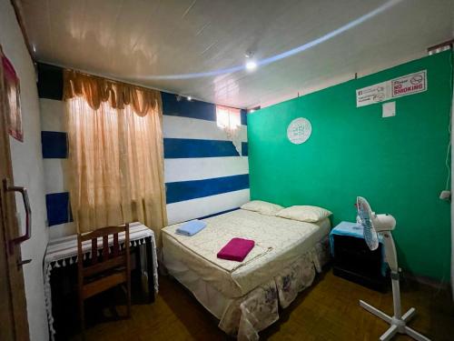 a bedroom with a bed and a green wall at Typical House Bluefields in Bluefields