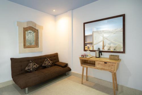 - un salon avec un canapé brun et une table dans l'établissement Angel House Ubud Eco Villa, à Ubud
