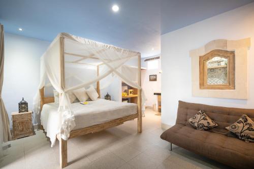 - une chambre avec un lit à baldaquin et un canapé dans l'établissement Angel House Ubud Eco Villa, à Ubud