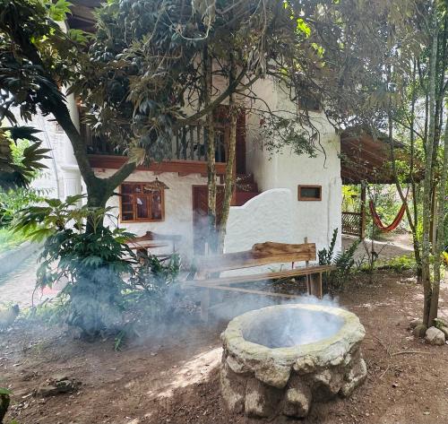 a stone fire pit in front of a house at Casa Museo - Naturaleza y Tradición in Otavalo
