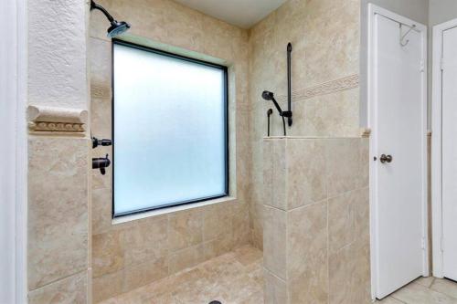 a bathroom with a shower and a window at Grapevine Oasis, with Pool in Grapevine