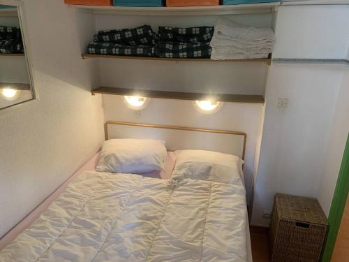 - un petit lit dans une petite chambre avec des lumières dans l'établissement Appartement T2 pour 4, terrasse vue mer, proche plages, parking inclus à Sainte-Maxime - FR-1-768-68, à Sainte-Maxime