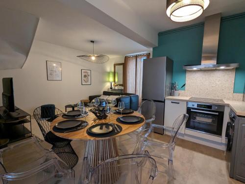 une cuisine et une salle à manger avec une table et des chaises dans l'établissement Maison spacieuse avec terrasse, proche CNDBI, idéale pour familles et événements, animaux acceptés. - FR-1-653-249, à Saint-Yrieix-sur-Charente