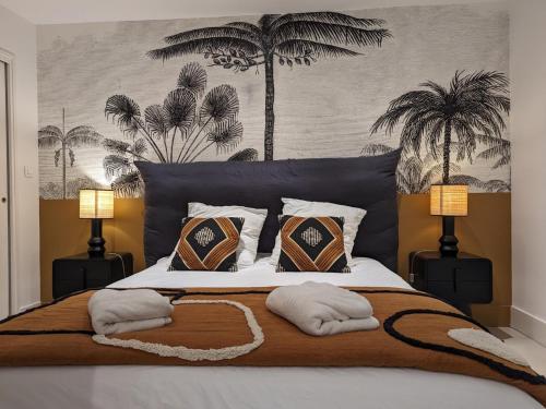 a bedroom with a large bed with pillows and palm trees at Gîte Saint-Yrieix-sur-Charente, 3 pièces, 6 personnes - FR-1-653-250 in Saint-Yrieix-sur-Charente