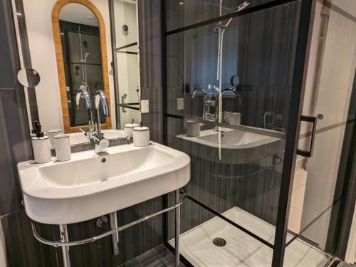 a bathroom with a sink and a glass shower at Gîte Saint-Yrieix-sur-Charente, 3 pièces, 6 personnes - FR-1-653-250 in Saint-Yrieix-sur-Charente